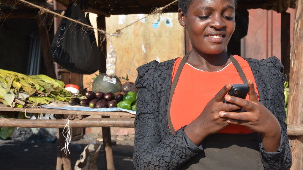 ug-business owner uses her phone for mobile banking-Anna Koblanck IFC